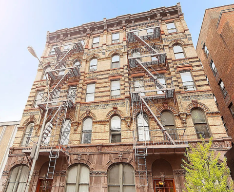 A large, old building with fire escapes on the side.