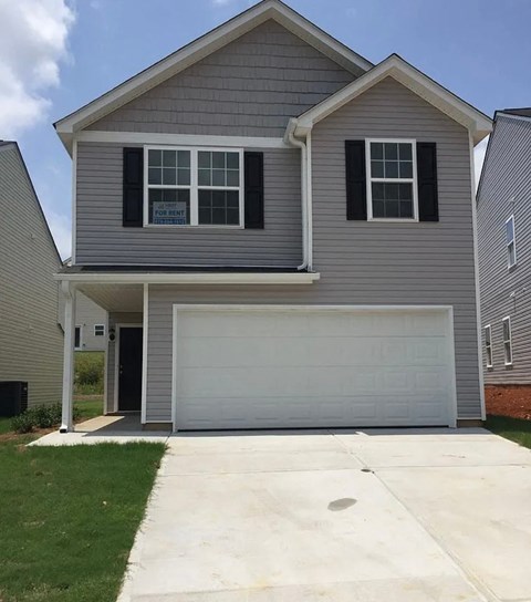 A grey house with a white garage door.