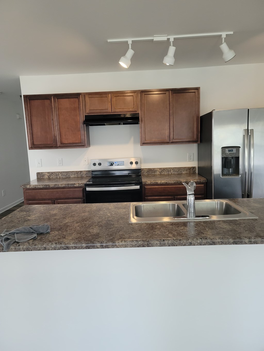 A kitchen with brown cabinets and a granite countertop.