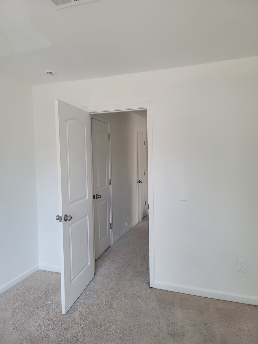 A white door is open to a hallway.