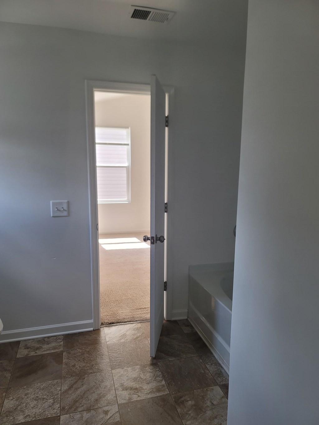 A white door is open to a bathroom.