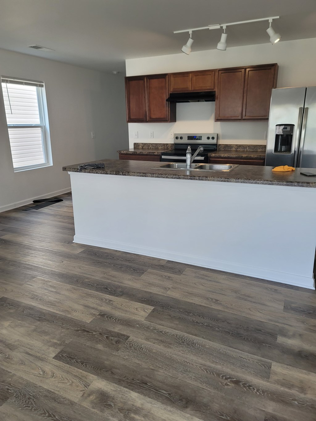 A kitchen with a white counter and wooden cabinets.