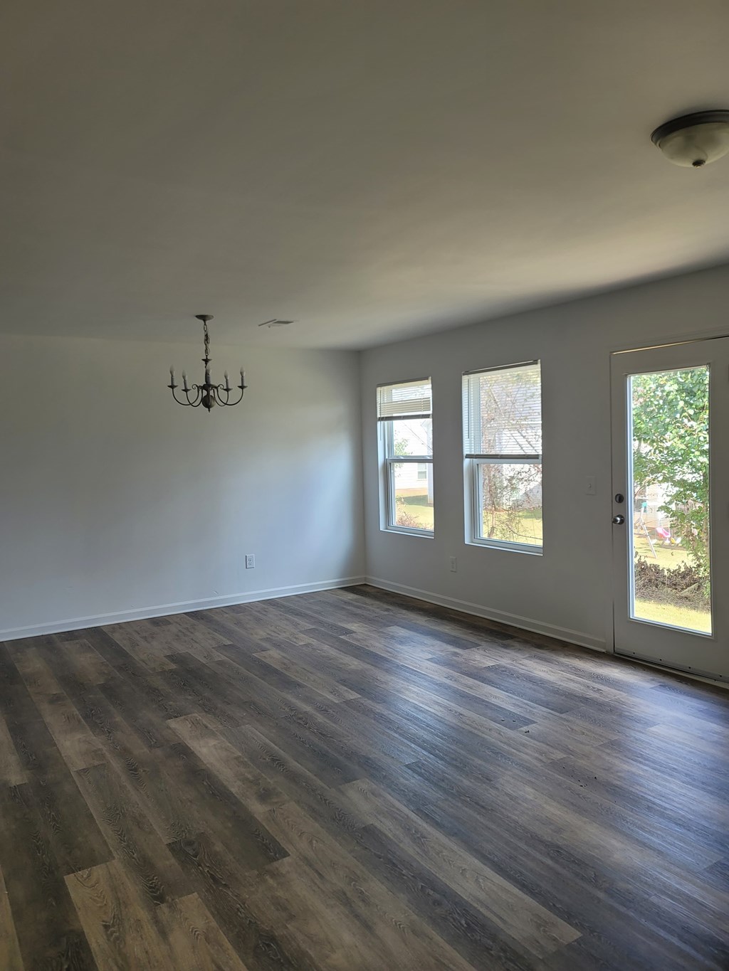 A room with wooden floors and a chandelier.
