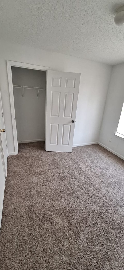 A room with a carpeted floor and a white door.