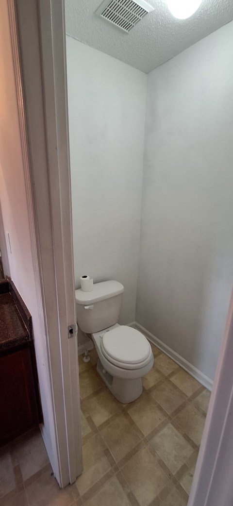 A white toilet in a small bathroom.