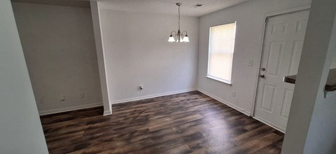 A room with wooden floors and a white door.