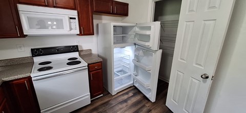 A kitchen with a white fridge and a white oven.
