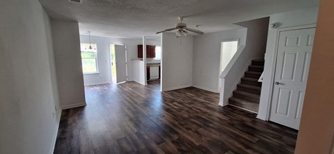 A room with a staircase and a ceiling fan.