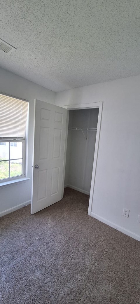 A room with a carpeted floor and a white door.