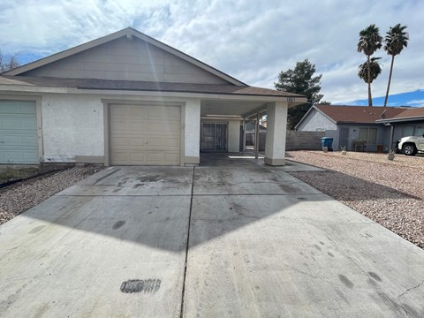 A house with a garage and driveway in front of it.