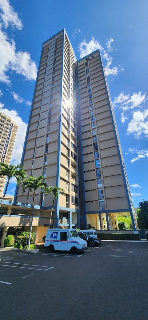 A tall building with a white van parked in front of it.