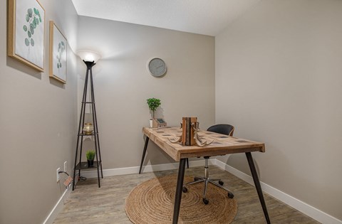 A room with a wooden table and a plant on it.