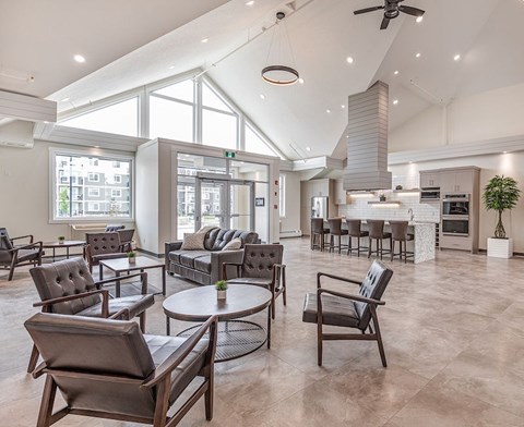 A modern living room with a glass table and leather chairs.