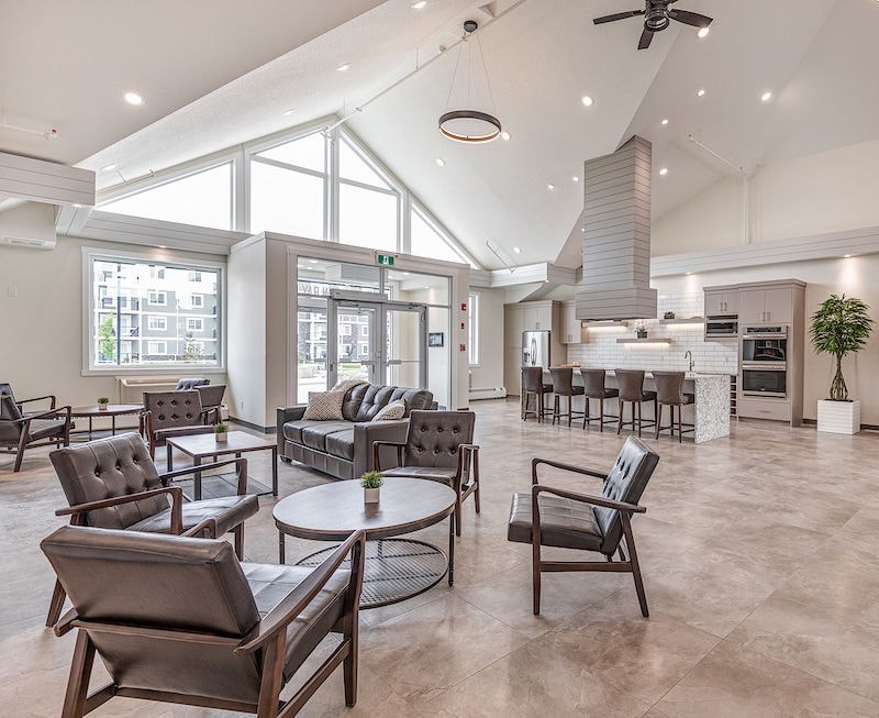 A modern living room with a glass table and leather chairs.