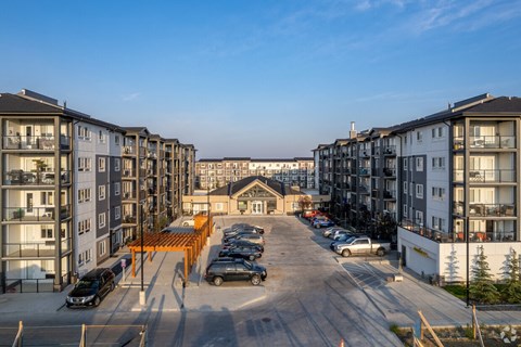A parking lot in front of apartment buildings.