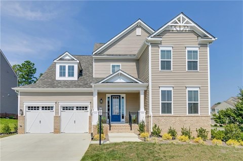 A two-story house with a blue front door and white garage doors.