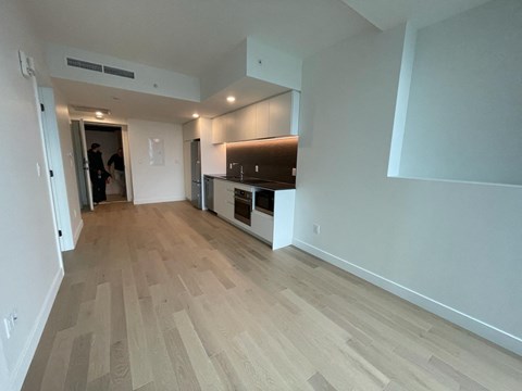 A room with wooden flooring and a person standing in the doorway.