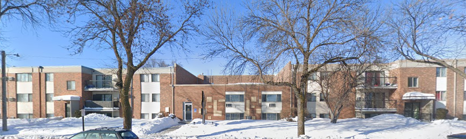 A large red brick building with a black car in front.