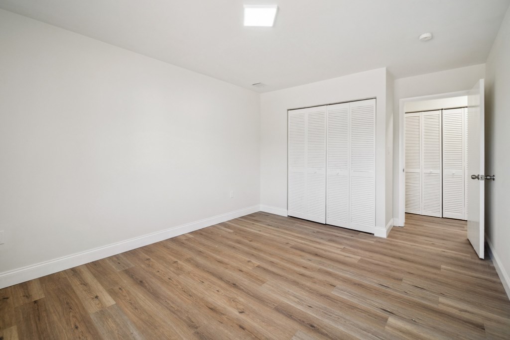 A room with wooden flooring and white walls.
