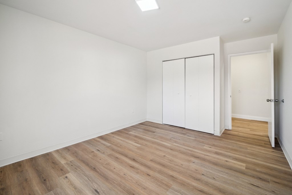 A room with a white wall and a white door with a white cabinet.
