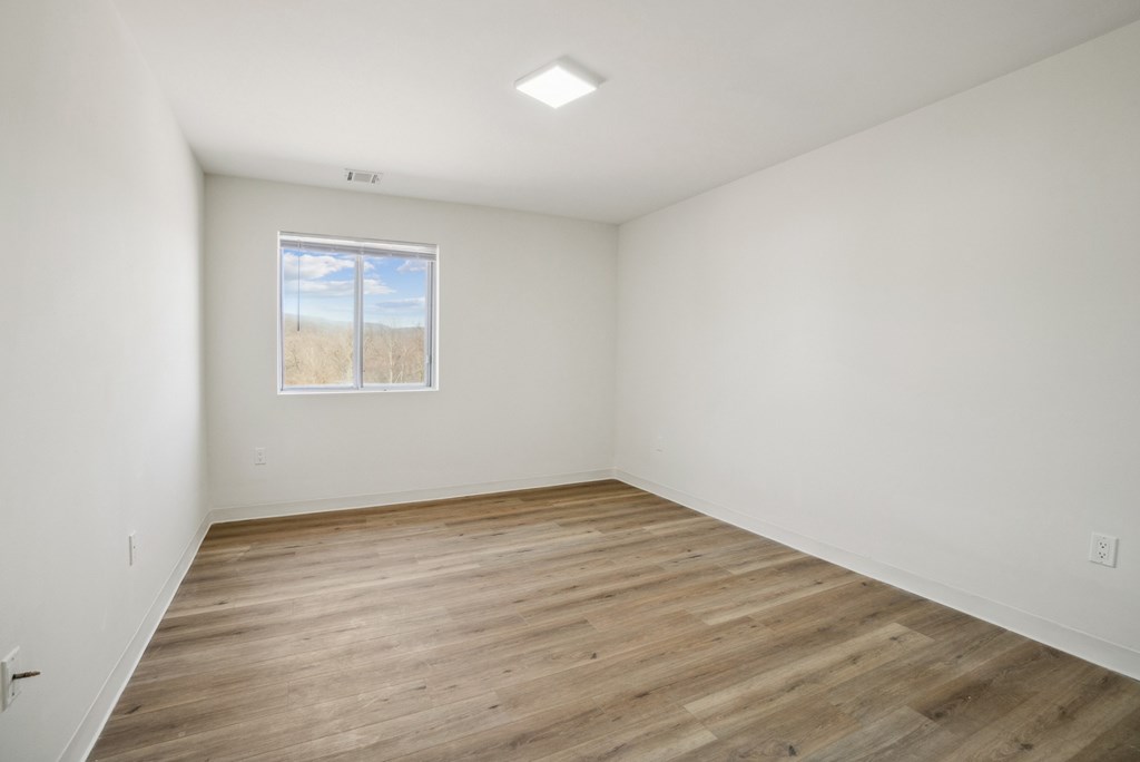 Empty room with wooden floor and a window.