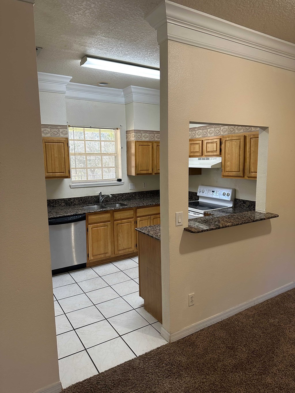 A kitchen with wooden cabinets and a black countertop.
