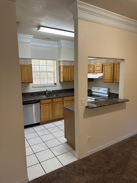A kitchen with wooden cabinets and a black countertop.