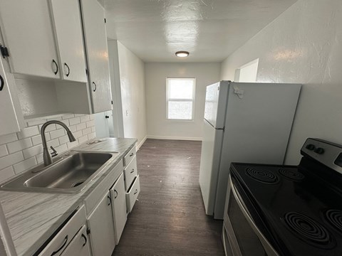 A kitchen with white cabinets and a black stove top oven.