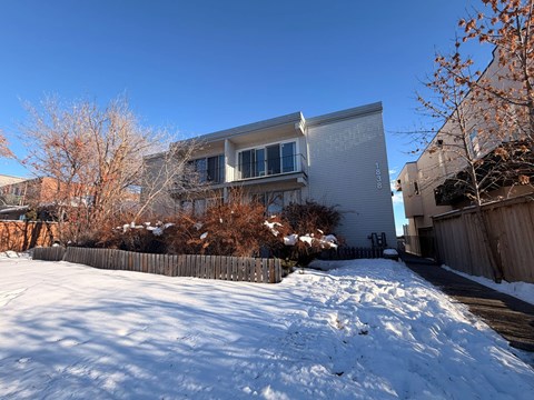 A snow-covered ground with a building in the background.
