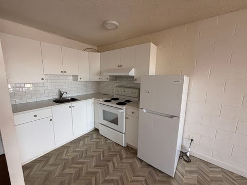 A kitchen with white appliances and a white refrigerator.