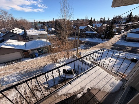 A view from a balcony overlooking a snowy residential area.