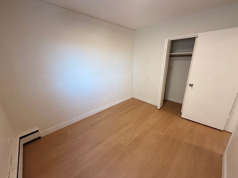 A room with a wooden floor and a white door.