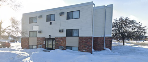 A modern building with a mix of brick and siding exterior is surrounded by snow.