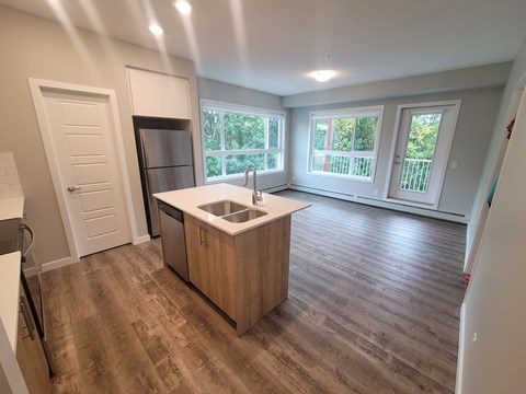 A kitchen with a sink and a refrigerator.