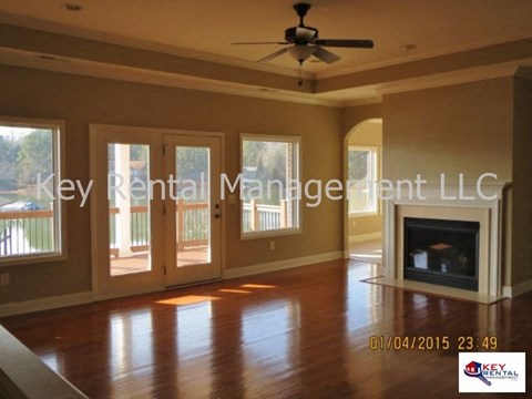 A living room with a fireplace and a ceiling fan.