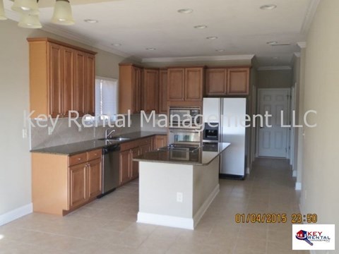 A kitchen with wooden cabinets and a black countertop.