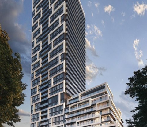 A tall building with a curved section at the bottom is surrounded by trees.