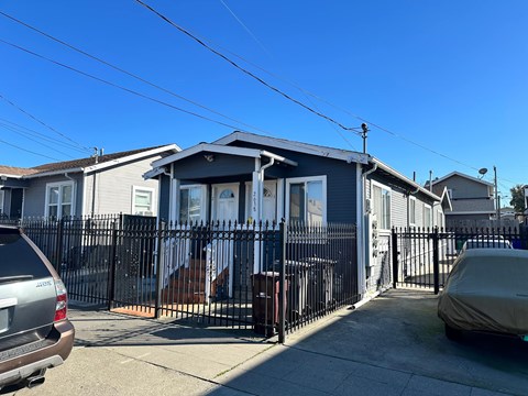 A house with a grey roof and a black fence.