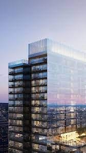 A tall glass building stands under a twilight sky.