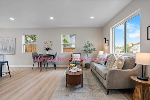 A living room with a couch, coffee table, and a painting on the wall.