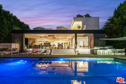A modern house with a pool in front.