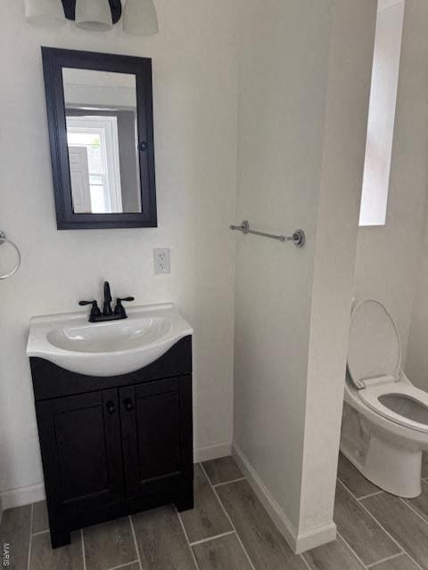 A bathroom with a sink, mirror, and toilet.