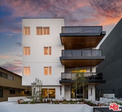 A modern two-story house with a balcony and a flat roof.