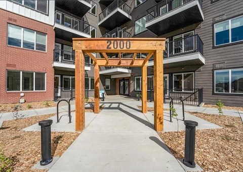 A wooden archway with the number 2000 on it is in front of a building.