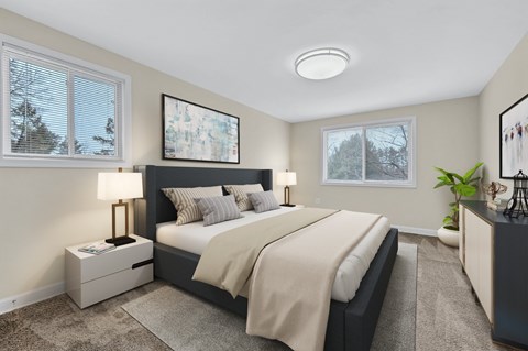 A bedroom with a large bed and a window with blinds.