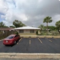 A red car is parked in a parking lot.