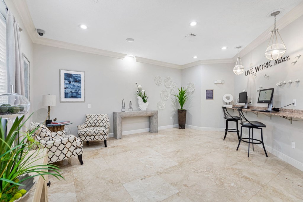 A well-lit room with a desk, chairs, and a plant.