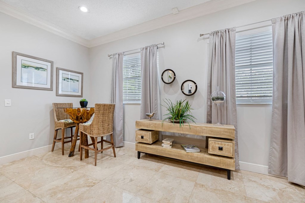 A room with a table and chairs and a clock on the wall.