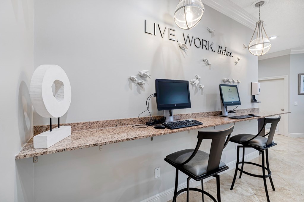 A workspace with a desk, chairs, and a computer setup.
