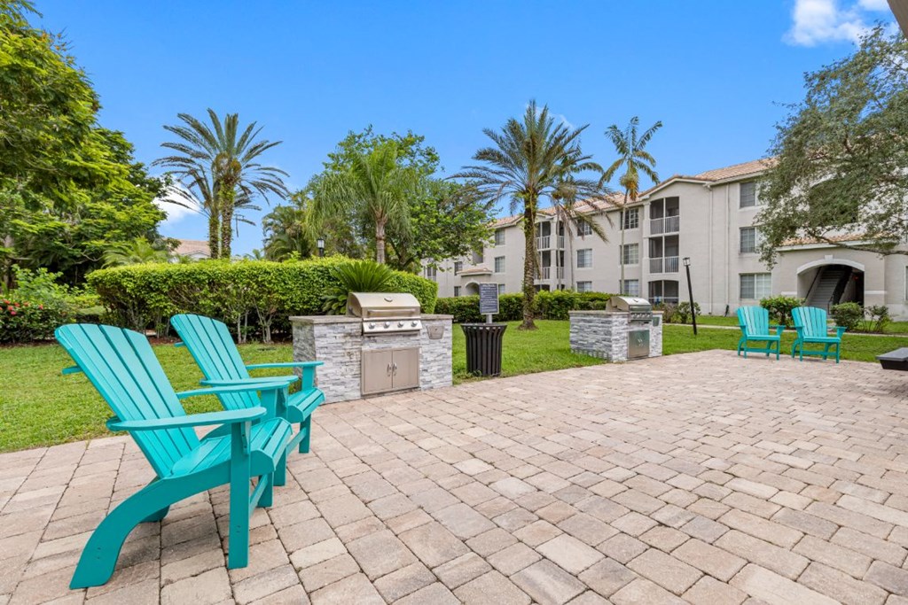 A patio with two green chairs and a table.